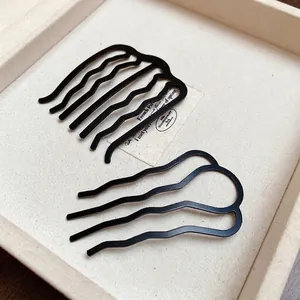 Minimalist black U-shaped wavy hairpins set for messy bun styling in elegant box
