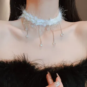 Vue détaillée d'un élégant ras-du-cou blanc en peluche avec des glands en cristal