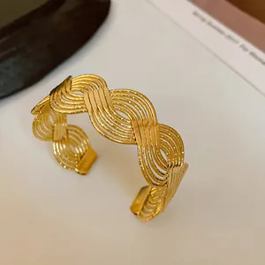 Close-up of golden braided multi-strand open cuff bracelet in minimalist style