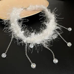 Vue détaillée d'un collier blanc duveteux orné de glands en perles de cristal étincelantes.