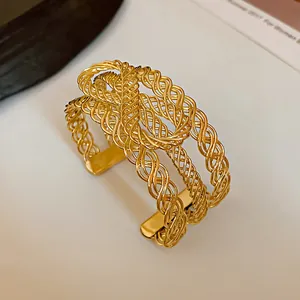 Close-up detail showing the intricate multi-strand gold woven design of this open cuff bracelet