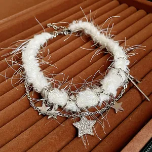 Détail en gros plan du collier blanc en peluche avec pendentifs étoiles et cristaux