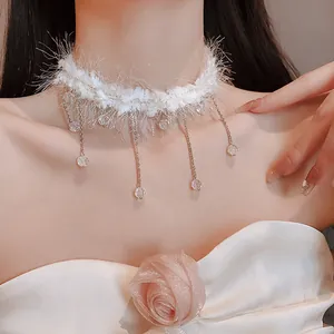 Détail d'un ras-de-cou en peluche blanche avec d'élégants glands en cristal et chaînes.