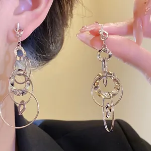 Elegant silver needle knotted hoop earrings with rippled texture and multi-circle design.