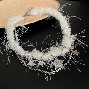 Gros plan d'un collier en peluche blanche orné de charms étoiles en cristal argenté.