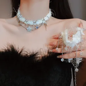 Détail d'un ras du cou blanc en peluche avec des pampilles en cristal et étoiles scintillantes