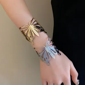 Detailed shot of textured gold and silver butterfly-shaped metal open cuff bracelets