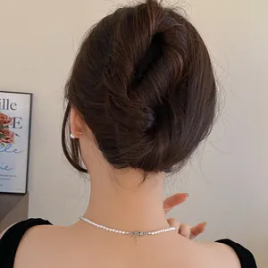 Elegant woman wearing minimalist U-shaped hair fork and pearl necklace for messy bun style