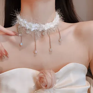 Élégant collier ras-de-cou en fourrure blanche avec délicats pompons en cristal sur modèle