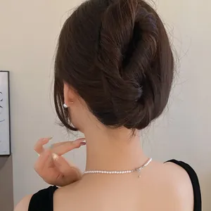 Elegant view of a minimalist black U-shaped hair fork securing a stylish messy bun hairstyle