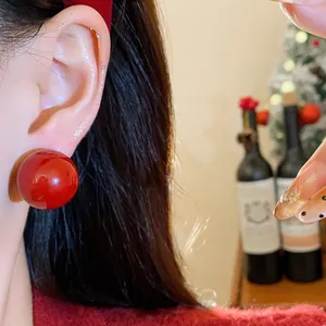 Elegante rote Perlenohrringe im französischen Stil am Ohr für einen festlichen Look