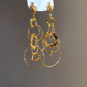Close-up view of elegant gold interlocking ring earrings with distinct hammered texture details