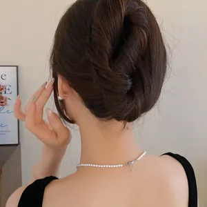 Detail of minimalist black U-shaped hair fork holding a stylish messy bun hairstyle