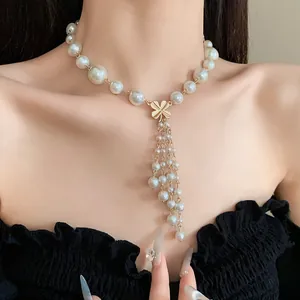 Elegante Perlenkette mit Blumenanhänger und Quasten-Detail am Hals