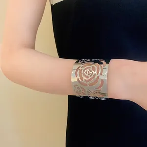Detail shot showing the elegant silver floral hollow-out cuff bracelet on a model
