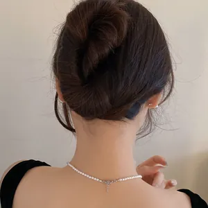 Back view of a sleek hair bun secured with a minimalist U-shaped hair fork accessory.