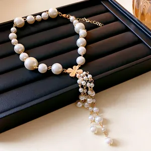 Detailansicht einer eleganten Kunstperlenkette mit goldenem Blumenquasten