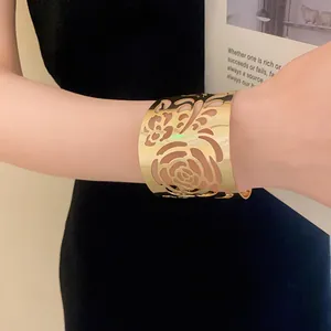 Close-up of golden hollow floral cuff bracelet with elegant rose pattern design