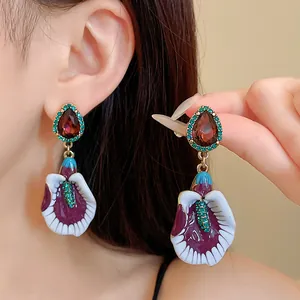 Close-up of vintage violet gradient floral drop earrings with red teardrop gemstone
