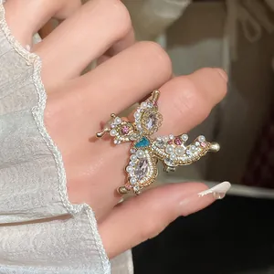 Detailed close-up of an elegant French style butterfly ring with pearls and rhinestones