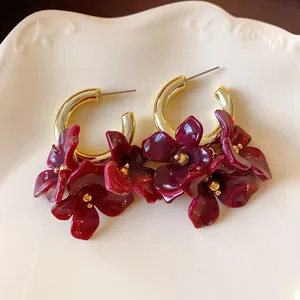 Close-up of vintage French style acrylic burgundy flower hoop earrings with gold accents