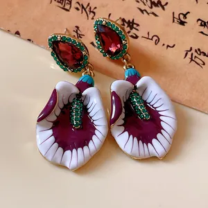 Close-up of vintage 3D floral earrings with purple enamel and red teardrop crystals.