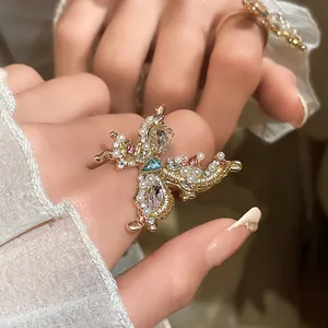 Close-up view of a delicate butterfly ring featuring white pearls and colorful crystals