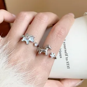 Detailed view of a silver horse and star ring with sparkling zircons on a model's finger
