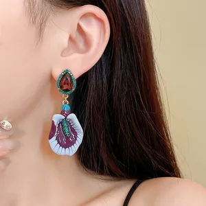 Close-up view of vintage purple floral relief earrings with gemstone accents.