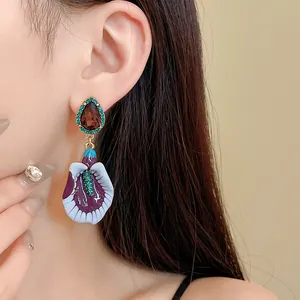 Close-up view of vintage-style violet gradient flower earrings with teardrop gemstone.