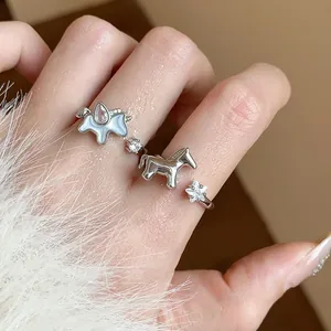 Close-up view of elegant silver horse and star rings with zircon stones on fingers