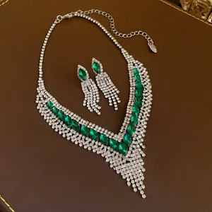 Vue détaillée d'un collier vintage avec gemmes vertes, strass et boucles d'oreilles assorties