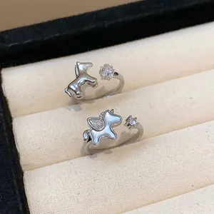 Macro view of silver-plated open rings with pony and unicorn designs featuring sparkling zircons.