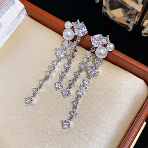 Elegant long drop earrings with brilliant cubic zirconia and pearls in a luxury box.