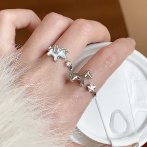 Close-up of zircon star and pony rings on hand with white furry sleeve detail