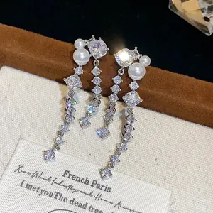 Detailed view of elegant silver long drop earrings with sparkling cubic zirconia and pearls