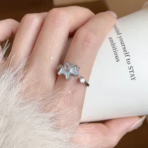 Close-up detail of silver unicorn open ring with water-drop zircon and round stone