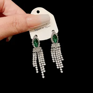 Gros plan sur des boucles d'oreilles vintage à pampilles en strass vert émeraude