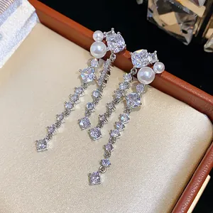 Detailed macro shot of elegant zircon and pearl dangling earrings in a luxury gift box