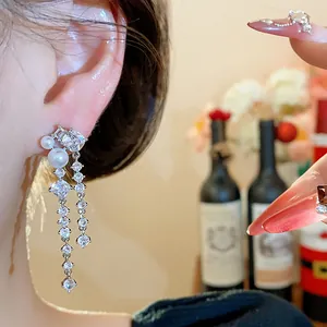 Elegant dangling zircon pearl earrings with Korean style design shown on an Asian model.