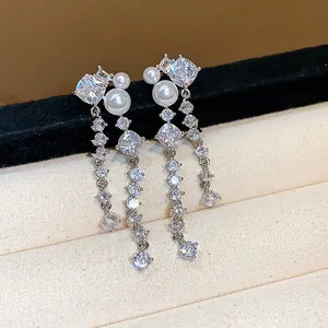 Exquisite silver-tone earrings detailed with sparkling cubic zirconia and white pearls.