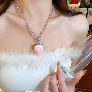 Primo piano di una collana di perline rosa con un ciondolo a forma di fragola floccata