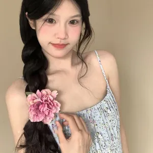Large pink fabric peony flower hair clip for bun styling worn by a model in a floral dress
