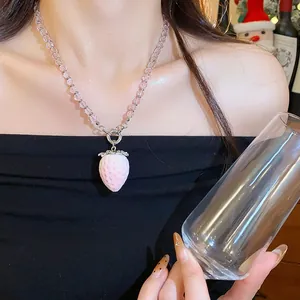 Vista dettagliata di una collana di perle a forma di fragola rosa indossata al collo