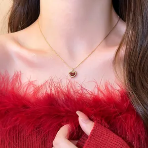 Elegant gold clavicle chain necklace featuring a red enamel heart pendant detail
