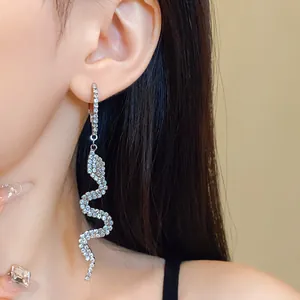 Detailed macro view of a sparkling rhinestone-encrusted snake-shaped drop earring.