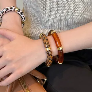 Vintage acrylic leopard and amber marbled bracelets on wrist with gold accents