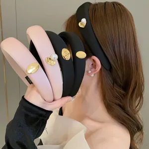 Close-up detail of padded sponge headbands featuring gold heart and pearl accents on model