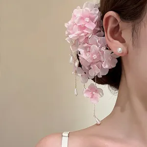 Close-up of pink fabric floral hydrangea hair clip with elegant pearl tassels on model