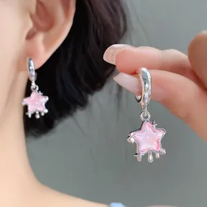 Dettaglio ravvicinato di orecchini a forma di stella in resina rosa con strass lucenti